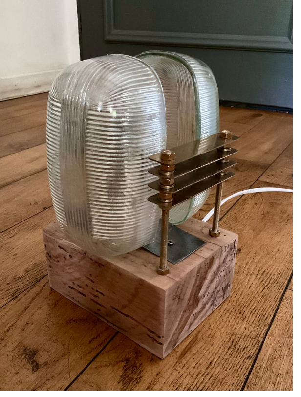 Un phare dans la nuit : lampe façon phare de voiture ancienne, globes en verre montés sur un bloc de bois