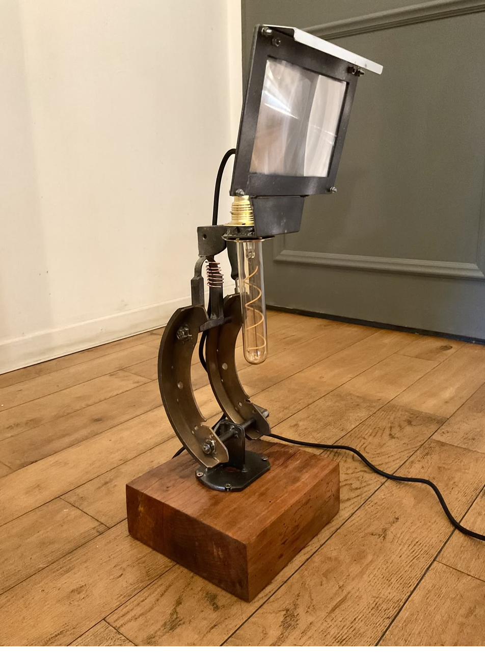 Vue d'ensemble du Lumicroscope éteint : deux mâchoires de frein forment le corps du microscope, surmontées d'un écran-loupe orientable